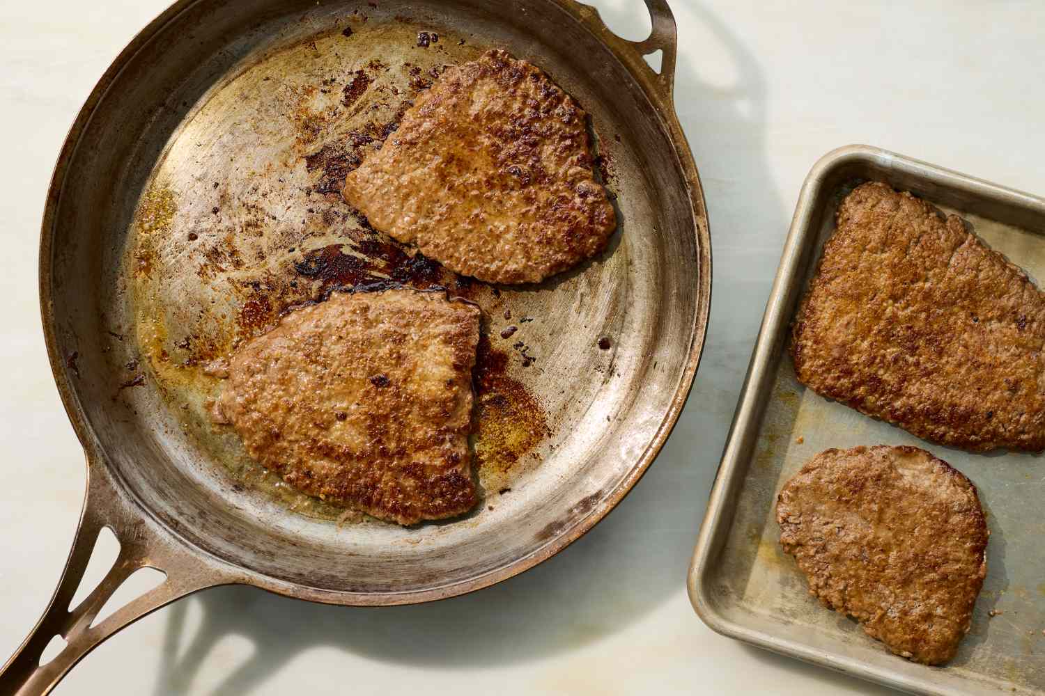 Cube steaks browning in a cast iron skillet with a light flour coating